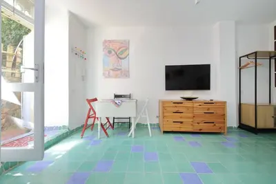 a living room with a television and a table with a chair at Casa Gaudì in Rome