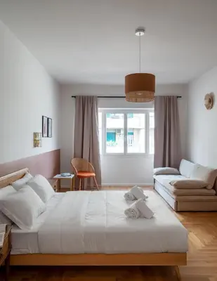 a white bedroom with a bed and a couch at Zen Trastevere Luxury Room - Zen 54 in Rome