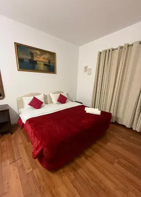 a bedroom with a large bed with a red blanket at Two Ducks Hostel in Rome