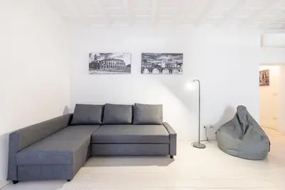 a living room with a couch and a floor lamp at Maison Parlamento - Roma centro in Rome