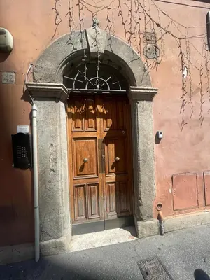 a large wooden door of a building with an arch at Monti loft al Colosseo in Rome