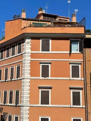 an orange building with shuttered windows on top at Monti loft al Colosseo in Rome