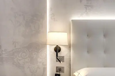 a bedroom with a bed and a lamp on a wall at The Spotlight Boutique Hotel in Rome