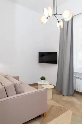 a white living room with a couch and a tv at Angelico living Rome in Rome