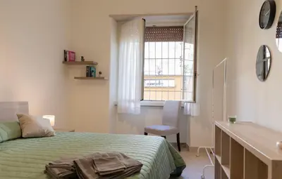 a bedroom with a bed and a desk and a window at Annmarie House, Vaticano - Cipro in Rome