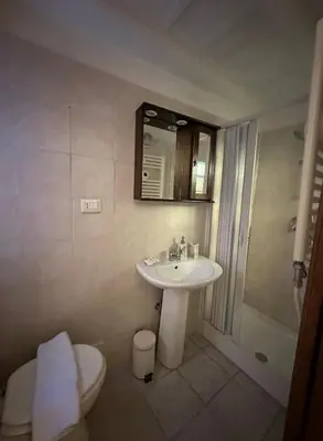 a bathroom with a sink and a toilet and a mirror at Arco acetari-Il medio evo nel cuore di roma in Rome