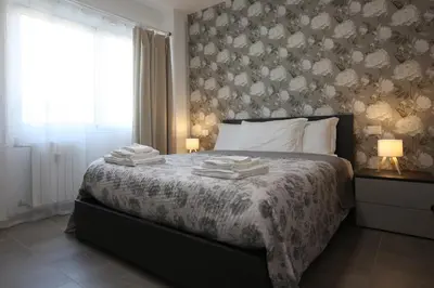 a bedroom with a bed with a floral wallpaper at Sweet Home Fleming in Rome