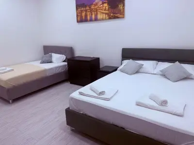 a room with two beds and a picture on the wall at Gazi House in Rome