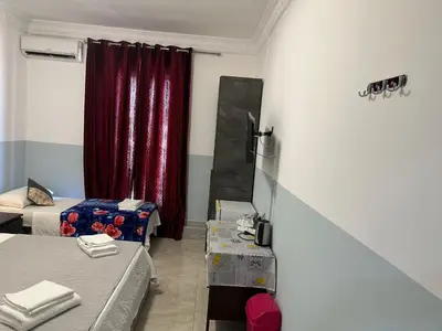 a room with two beds and a red curtain at TERMINI ROMA CENTRo in Rome
