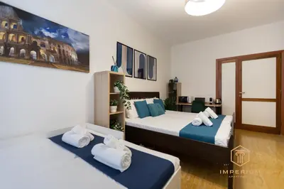 two beds in a room with white and blue at Imperium Garbatella Guesthouse - 2 bedrooms with private bathroom, Terrace, 800mt to metro in Rome