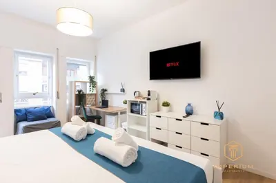 a bedroom with a bed and a tv on the wall at Imperium Garbatella Guesthouse - 2 bedrooms with private bathroom, Terrace, 800mt to metro in Rome
