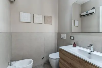 a bathroom with a white sink and a toilet at Trevi Central Suite in Rome