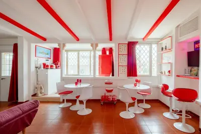 a living room with two white tables and red chairs at Vatican PENTHOUSE in Rome