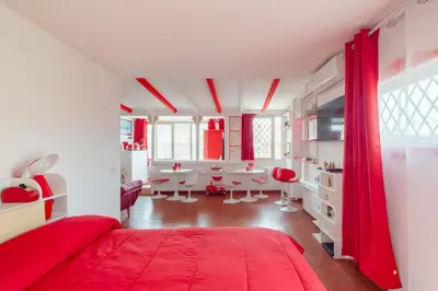 a bedroom with red curtains and a dining room at Vatican PENTHOUSE in Rome