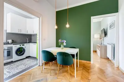 a kitchen and dining room with green walls and a table and chairs at Attico incantevole con idromassaggio e terrazzo in Rome