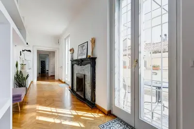 a living room with a fireplace and a large window at Attico incantevole con idromassaggio e terrazzo in Rome