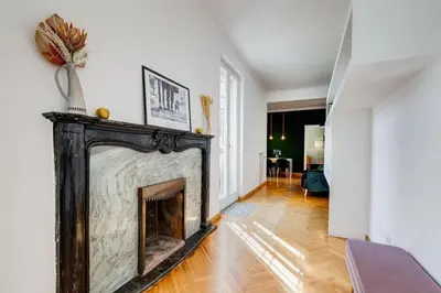 a fireplace in a living room with white walls and wooden floors at Attico incantevole con idromassaggio e terrazzo in Rome