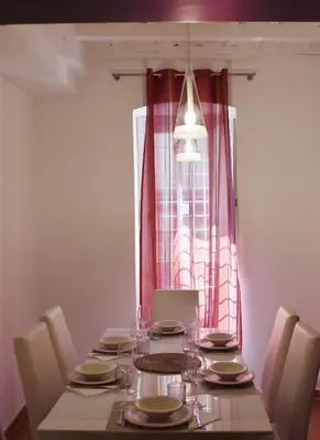 a dining room table with chairs and a large window at Apartment in Campo de' Fiori in Rome