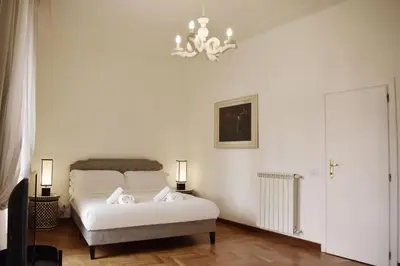 a white bedroom with a bed and two lamps at Apartment in Campo de' Fiori in Rome