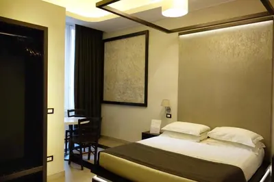 a bedroom with a bed and a table and a window at Campo De’ Fiori Prestige Rooms in Rome