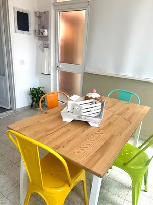 a wooden table with yellow chairs around it at La casa di Roby in Rome