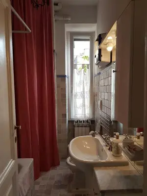 a bathroom with a sink and a red shower curtain at House of Marzia #6000rome in Rome