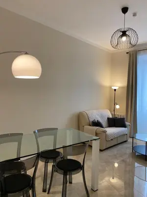 a living room with a glass table and chairs at Golden Round Palace in Rome