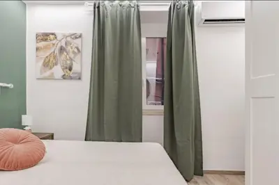 a bedroom with a bed with green curtains at Urbanflat Termini in Rome