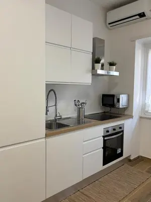 a kitchen with white cabinets and a sink at Domus Gregorio VII in Rome