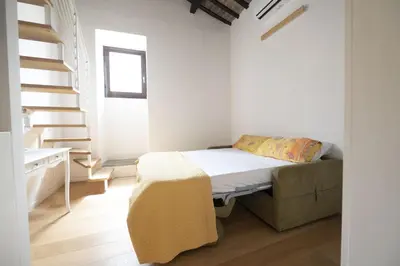a white bedroom with a bed and a staircase at Roman Dream in Campo de Fiori in Rome