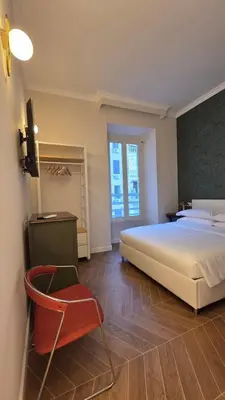 a bedroom with a white bed and a red chair at Luì & Giò Luxury Suite in Rome
