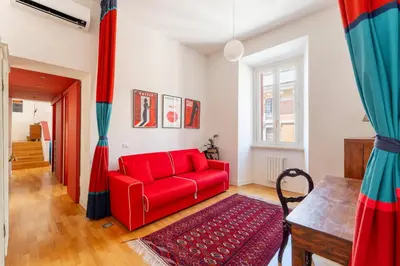 a living room with a red couch and a table at Casa Medina, Charme in 5 min From Villa Borghese in Rome