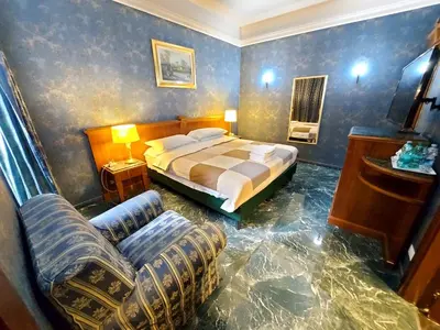 a bedroom with a bed and a couch and a chair at Alloggio Positano in Rome