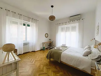 a bedroom with a large bed and a wooden floor at MamaCri rifugio d'inverno a Roma in Rome