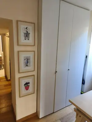 a room with a white cabinet and three pictures on the wall at Suite Tevere star in Rome