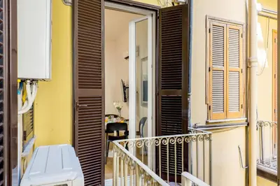a balcony with black shutters and a bench at The Best Rent - Modern one-bedroom apartment in the Porta Pia area in Rome