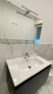 a bathroom with a white sink and a mirror at Vatican Museum YH in Rome