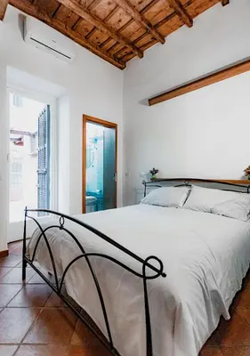 a white bedroom with a large bed in a room at Trastevere Urban Loft in Rome