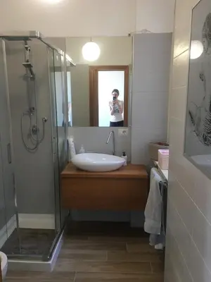 a woman taking a picture of a bathroom sink at Francy's home sweet home in Rome