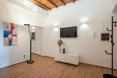 a room with white walls and a television and a lamp at Margherita Flat in Rome
