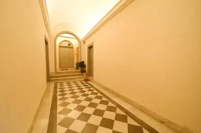 an empty hallway with a checkered floor in a building at Gian's Trevi BuddyRent in Rome