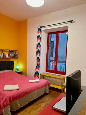 a bedroom with a red bed and a television at Trastevere Hideaway in Rome