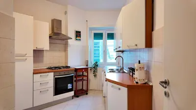 a small kitchen with white cabinets and a window at Vatican St Peter Apartment in Rome