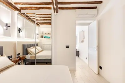 a bedroom with white walls and a bed in a room at Boutique Apartment Steps from Colosseum in Rome