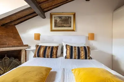 a bedroom with a white bed with yellow pillows at Attico con terrazza privata silenzioso casa Mem in Rome
