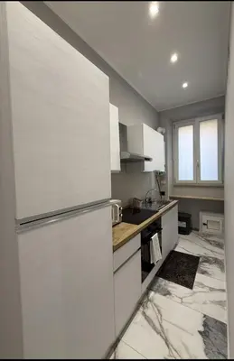 a kitchen with white cabinets and a refrigerator at Feffo's home - Casa per 4 persone in Rome
