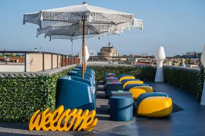 a row of chairs with an umbrella on a roof at Gracchi Vatican View in Rome