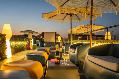 a restaurant with chairs and umbrellas on a roof at Gracchi Vatican View in Rome