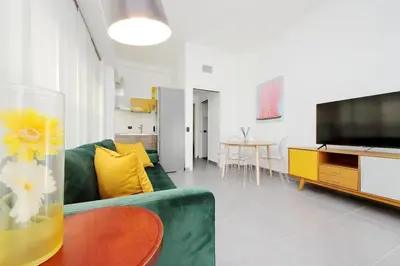 a living room with a green couch and a television at La Dolce Vita - Your perfect base to explore Rome in Rome