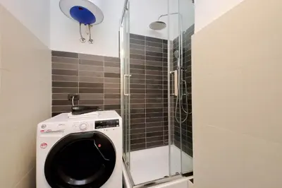 a bathroom with a washing machine and a shower at La Dolce Vita - Your perfect base to explore Rome in Rome